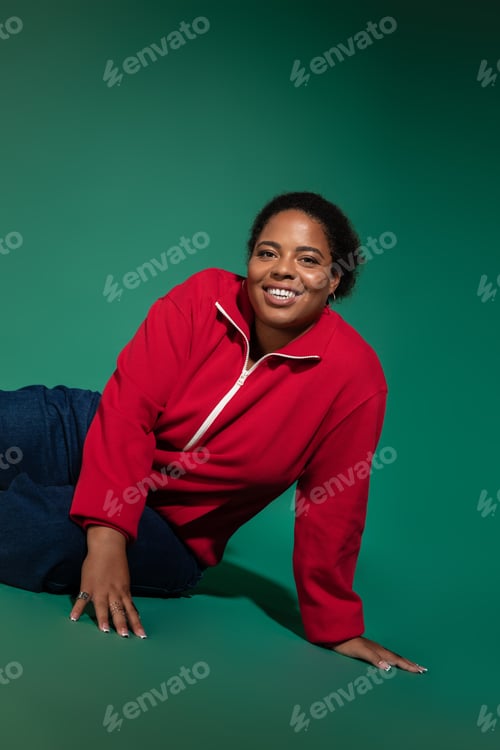 Preview: Fashionable plus size woman showcasing autumn style in studio setting