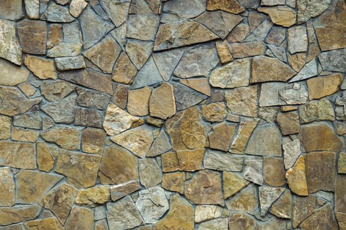 Preview: Wall of stone lined with brown limestone.