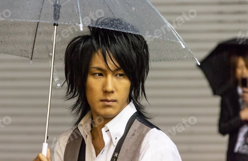 Preview: Japan - May, 10 2013: Asian man with umbrella looking away