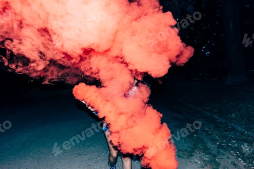 Preview: Woman holding flare in park at night