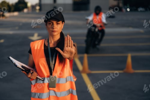 Preview: Stop hand gesture. Motorcycle driving license exam. Man and woman are in uniforms