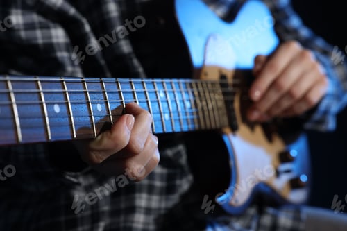 Preview: Woman playing guitar on black background, closeup