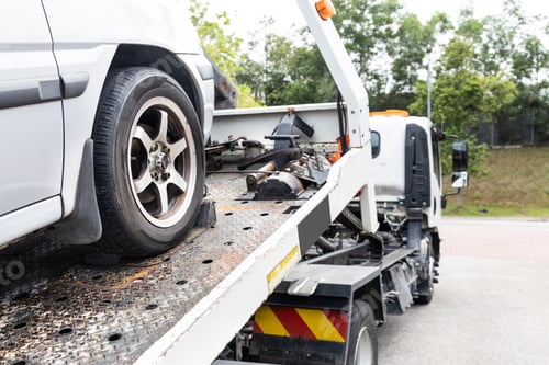 Preview: Cable attached to broken down car being pulled onto tow truck