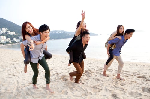 Preview: Excited young people playing piggyback on the beach of Repulse Bay, Hong Kong