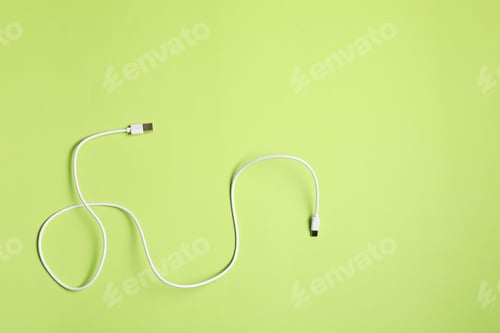 Preview: One USB charge cable on green background, top view.. Space for text