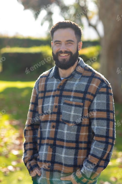 Preview: Vertical image of happy caucasian man looking at camera in garden