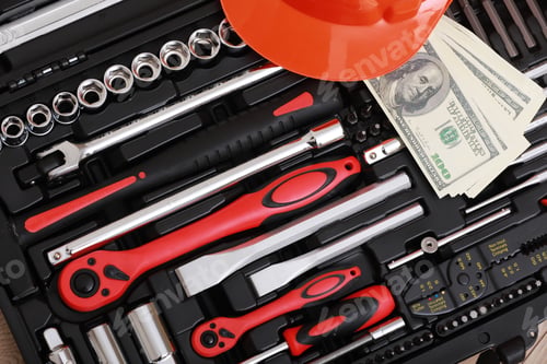 Preview: Toolbox, tools kit detail, dollar bills and orange protective helmet close up. instruments. set