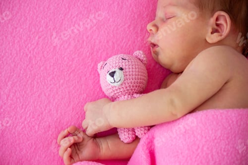 Preview: Sleeping newborn baby sleeping on bright pink blanket with a white knitted teddy bear.