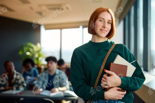 Preview: Smiling female university student in the classroom looking at camera.