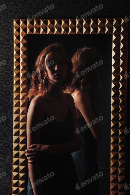 Preview: Portrait of pretty cute teenager girl in an elegant dress at mirror