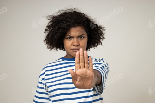 Preview: Sad curly young woman showing stop on white background