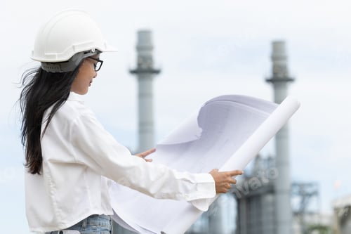 Preview: Professional smart young engineer women standing at refinery power plant building floor plan