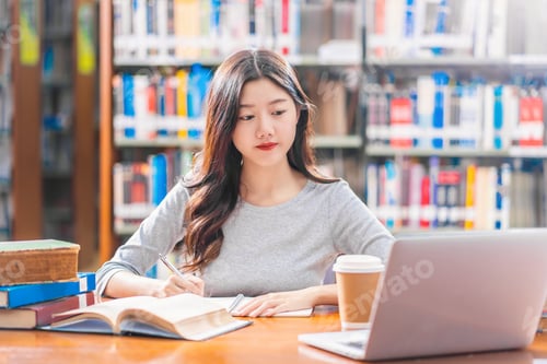 Preview: Asian young Student in casual suit doing homework and using technology laptop