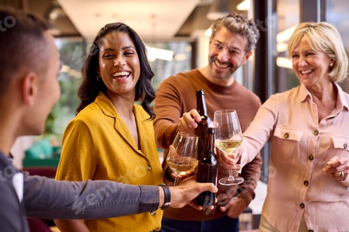 Preview: Staff At Informal Team Meeting In Office Celebrating With Drinks