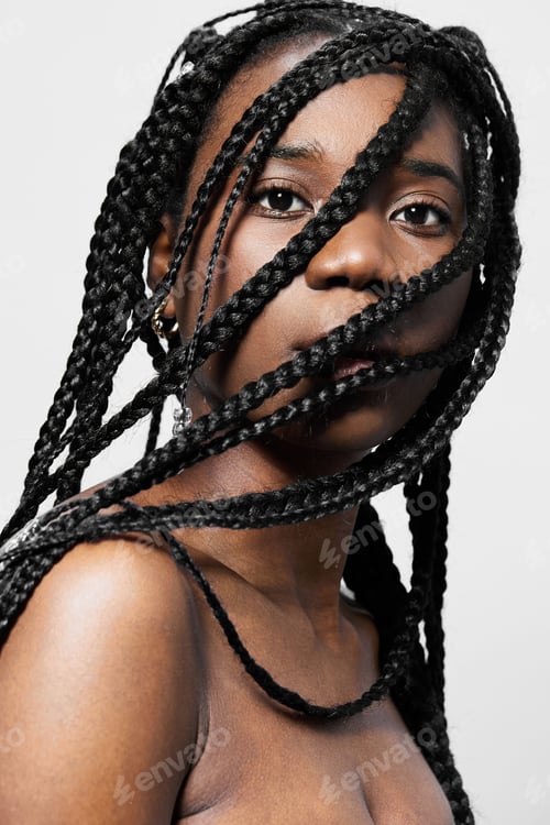 Preview: Portrait of a confident young woman with braided hair, conveying strength and beauty against a