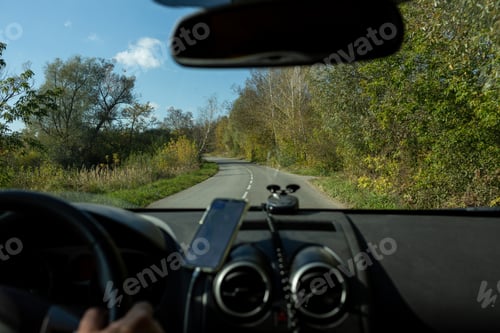 Preview: A man is driving in a car through a rural area