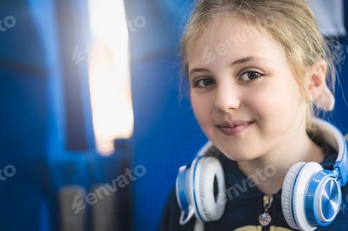 Preview: Cute little Caucasian girl with headphones on her back