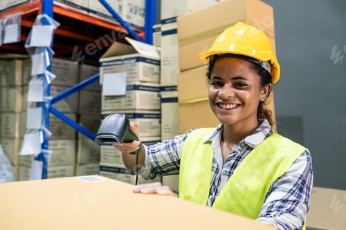Preview: Young smiling woman worker checking box in stock warehouse using bar code scanner equipment.