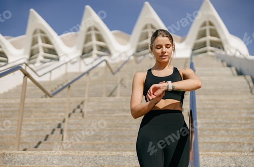 Preview: Woman Checking Activity Tracker After Exercise Outdoors