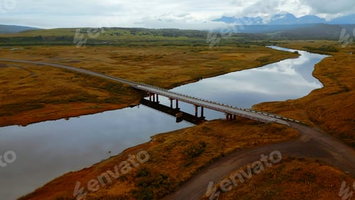 Preview: Aerial view of gorgeous nature a bridge between the river shores. Clip. Rural landscape with golden