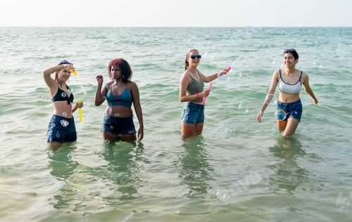 Preview: Group of teen girl enjoy and fun with soapsuds or soap bubbles during play together in the sea