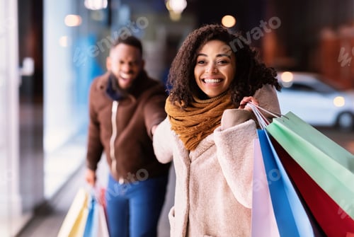 Preview: Excited Black Woman Pulling Boyfriend To Shopping Store