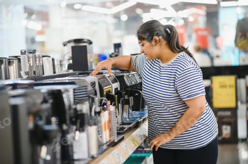Preview: Smart modern female customer choosing coffee machine at electronics store
