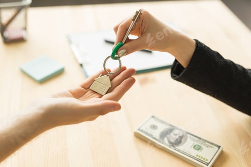 Preview: Business, realtor and real estate concept - Hand-to-hand key from new home
