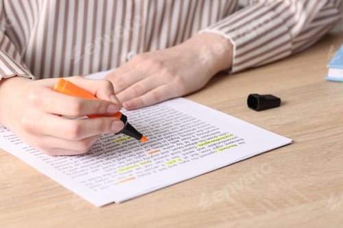 Preview: Woman highlighting important information at wooden desk indoors, closeup