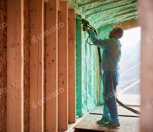 Preview: Worker spraying polyurethane foam for insulating wooden frame house.