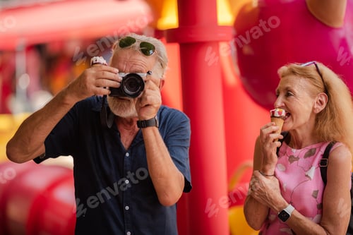 Preview: elderly senior couple woman and man having fun and happy together at amusement them park
