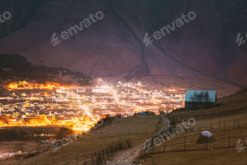 Preview: Stepantsminda, Georgia. Countryside Landscape At Evening Night Time On Mountain Background In