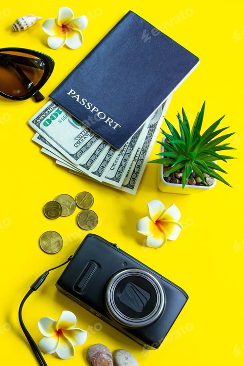 Preview: Summer travel concept. Passport, money, sunglasses and a camera on a yellow background.