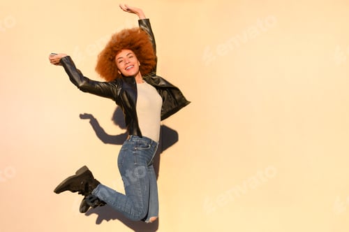 Preview: Happy girl with afro hair jumping in the city