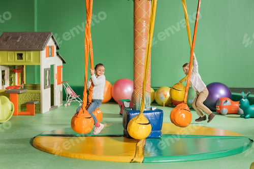 Preview: happy little children swinging and playing in entertainment center