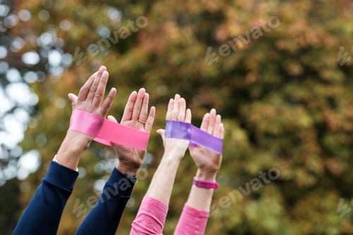 Preview: Mature women hands using resistance bands in park.
