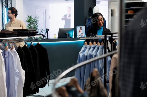 Preview: Clothing store employee hanging apparel