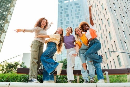 Preview: Group of playful female friends having fun on a social meeting. Young friendly women enjoying the
