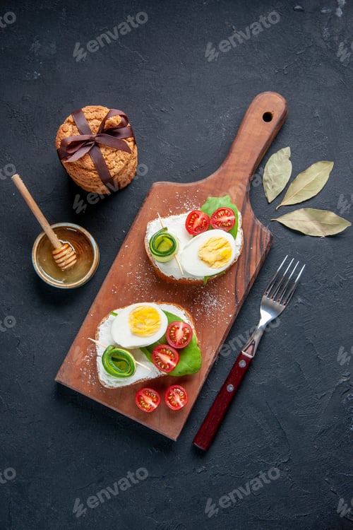 Preview: top view tasty sandwiches with tomatoes and eggs on cutting board dark background toast meal bread