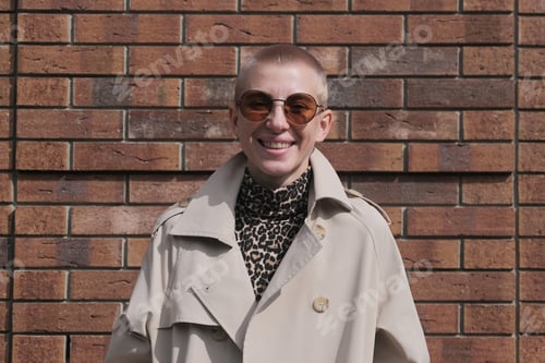 Preview: A Woman With Short Hair In Gray Coat And Glasses Dancing, Walking, Smiling On A City Street.