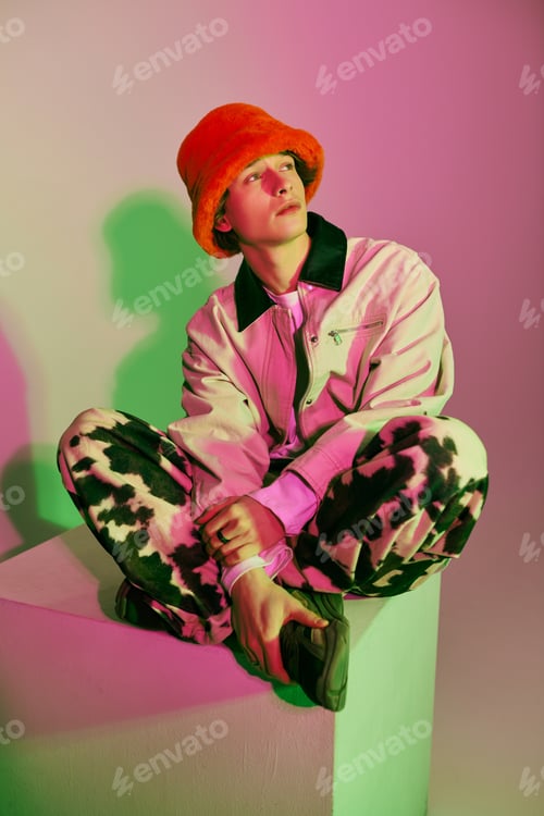 Preview: Young man showcases vibrant fashion style with a playful demeanor in a modern urban space
