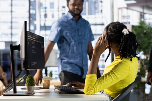 Preview: Programmer doing software debugging, asking for help from coworker