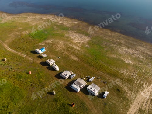 Preview: Aerial view of a campers van parked on a beach, mountain range landscape