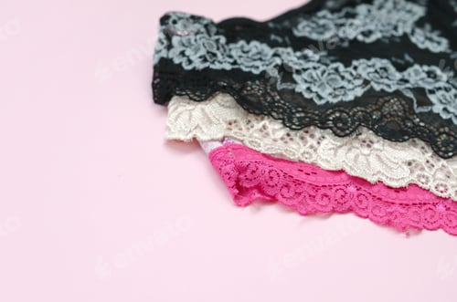 Preview: White, black and pink women underwear with lace on pink background close up with copy space