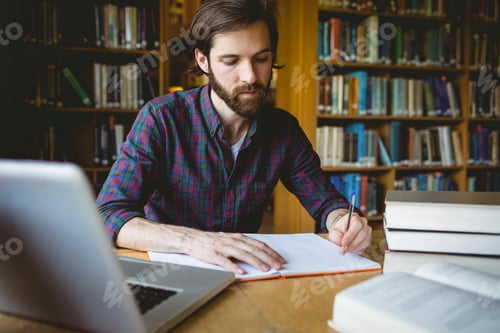 Preview: Hipster student studying in library at the university