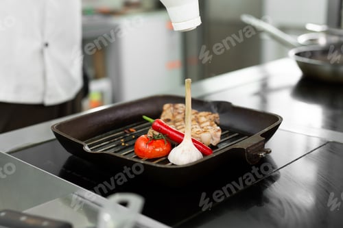 Preview: Grilled steak with tomato, pepper and garlic on a grill pan