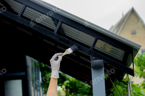 Preview: girl paint with a brush black metal. paints the roof.