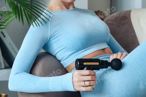 Preview: Gun shock therapy. Crop image sporty woman doing percussion massage