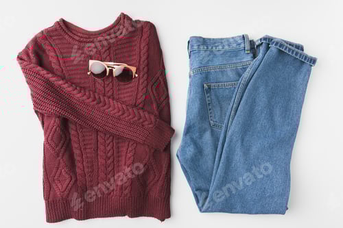 Preview: flat lay with burgundy knitted sweater, trendy jeans and sunglasses, isolated on white