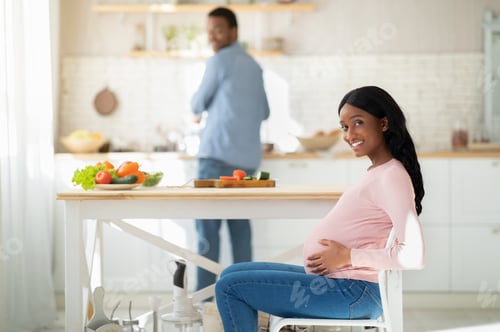 Preview: Healthy nutrition during pregnancy. Lovely expectant woman waiting for her husband to cook healthy